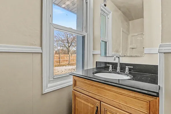 a bathroom with a granite countertop sink and a vanity