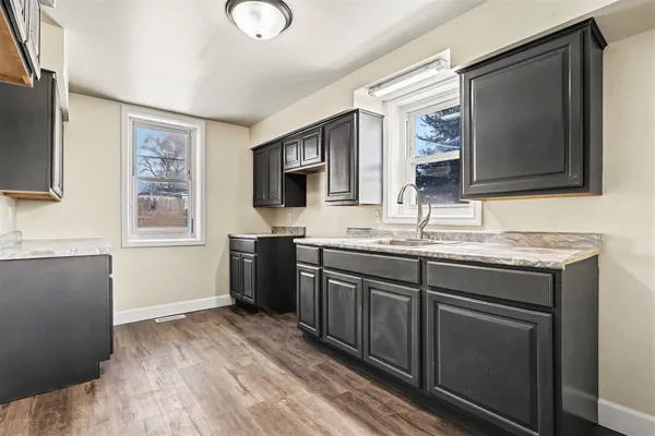 a bathroom with a granite countertop double vanity sink and mirror