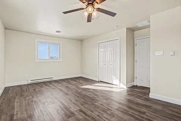 a view of an empty room with wooden floor