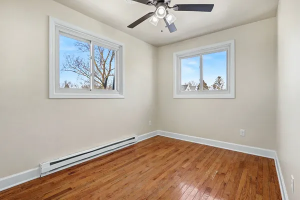 a view of empty room with wooden floor