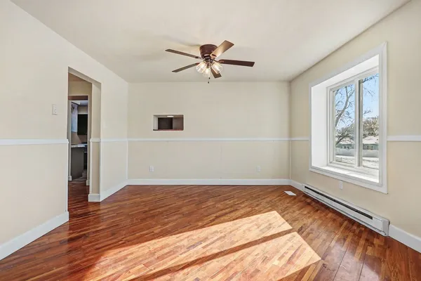 a view of a livingroom with wooden floor and a ceiling fan