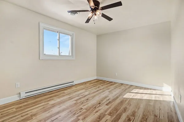 wooden floor in an empty room with a window