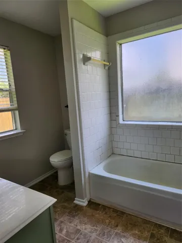 a bathroom with a toilet and a bathtub