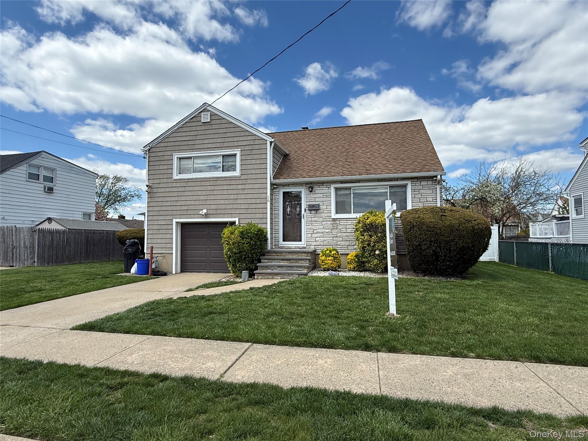 16 Layton Street Freeport, NY 11520 - Photo 1 of 17 a front view of a house with a yard and garage