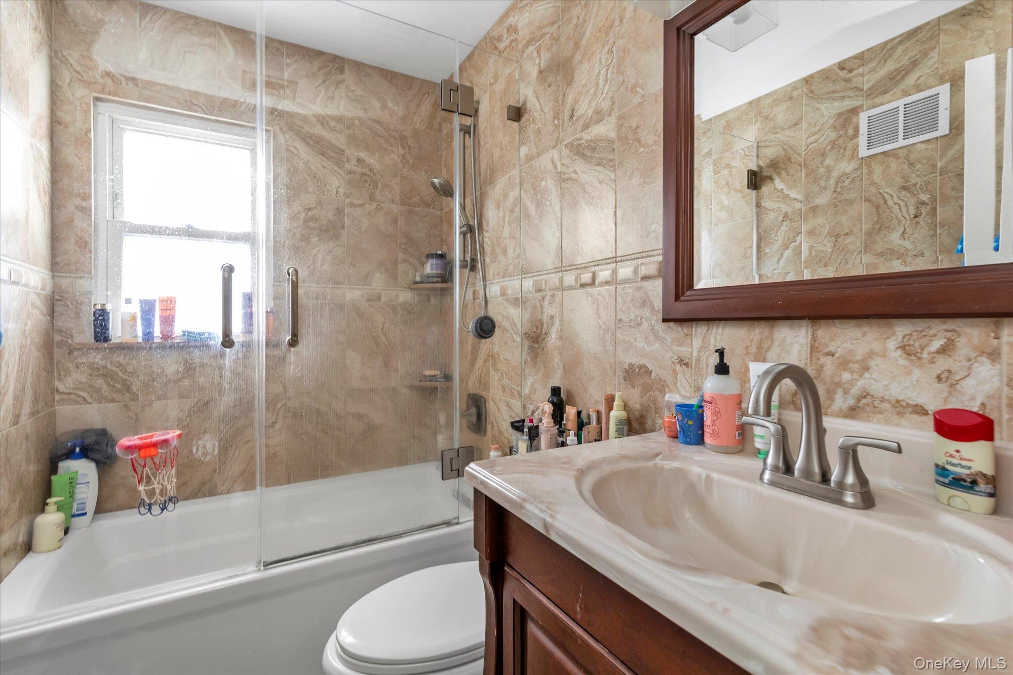 16 Layton Street Freeport, NY 11520 - Photo 12 of 17 a bathroom with a granite countertop sink a toilet and shower