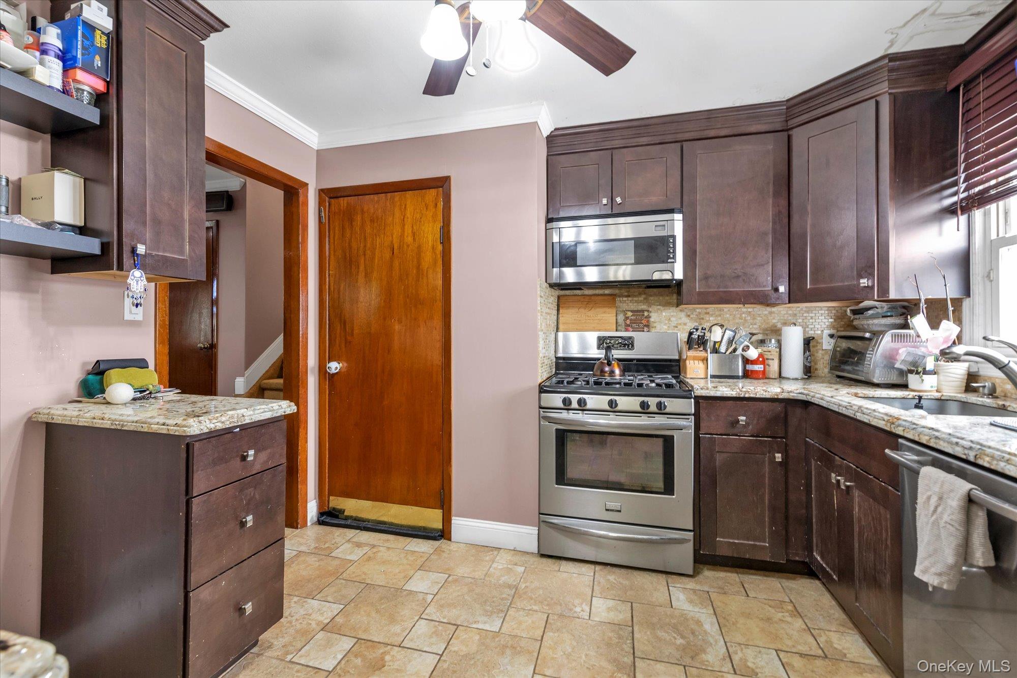 16 Layton Street Freeport, NY 11520 - Photo 6 of 17 a kitchen with stainless steel appliances granite countertop a stove a sink and a refrigerator