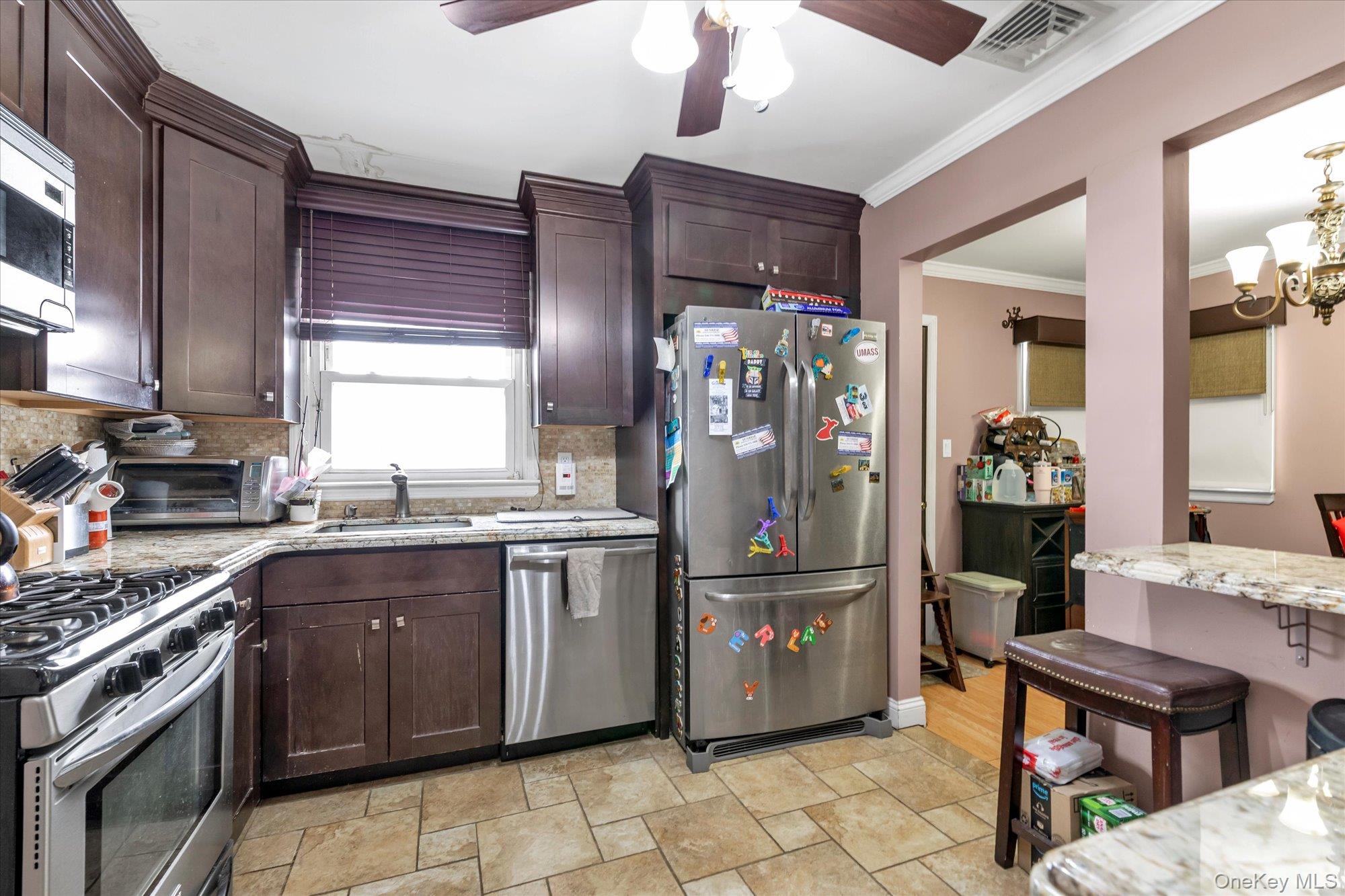 16 Layton Street Freeport, NY 11520 - Photo 7 of 17 a kitchen with stainless steel appliances granite countertop a refrigerator and a stove top oven