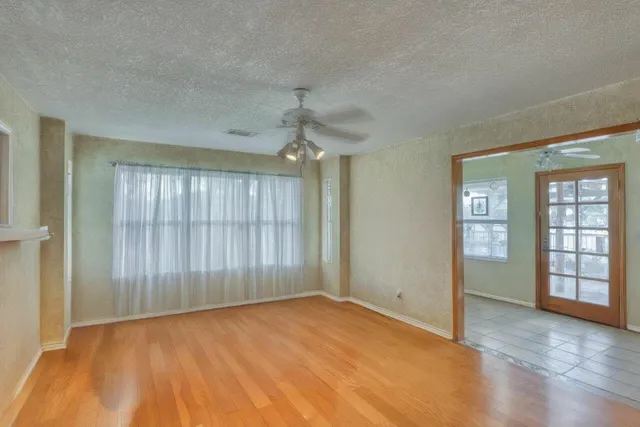 a view of an empty room with wooden floor