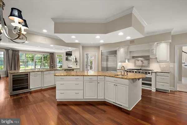 a kitchen with stainless steel appliances granite countertop a stove and a wooden floors