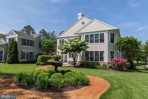 a front view of a house with a yard and potted plants