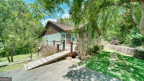 a view of backyard with large trees and wooden fence