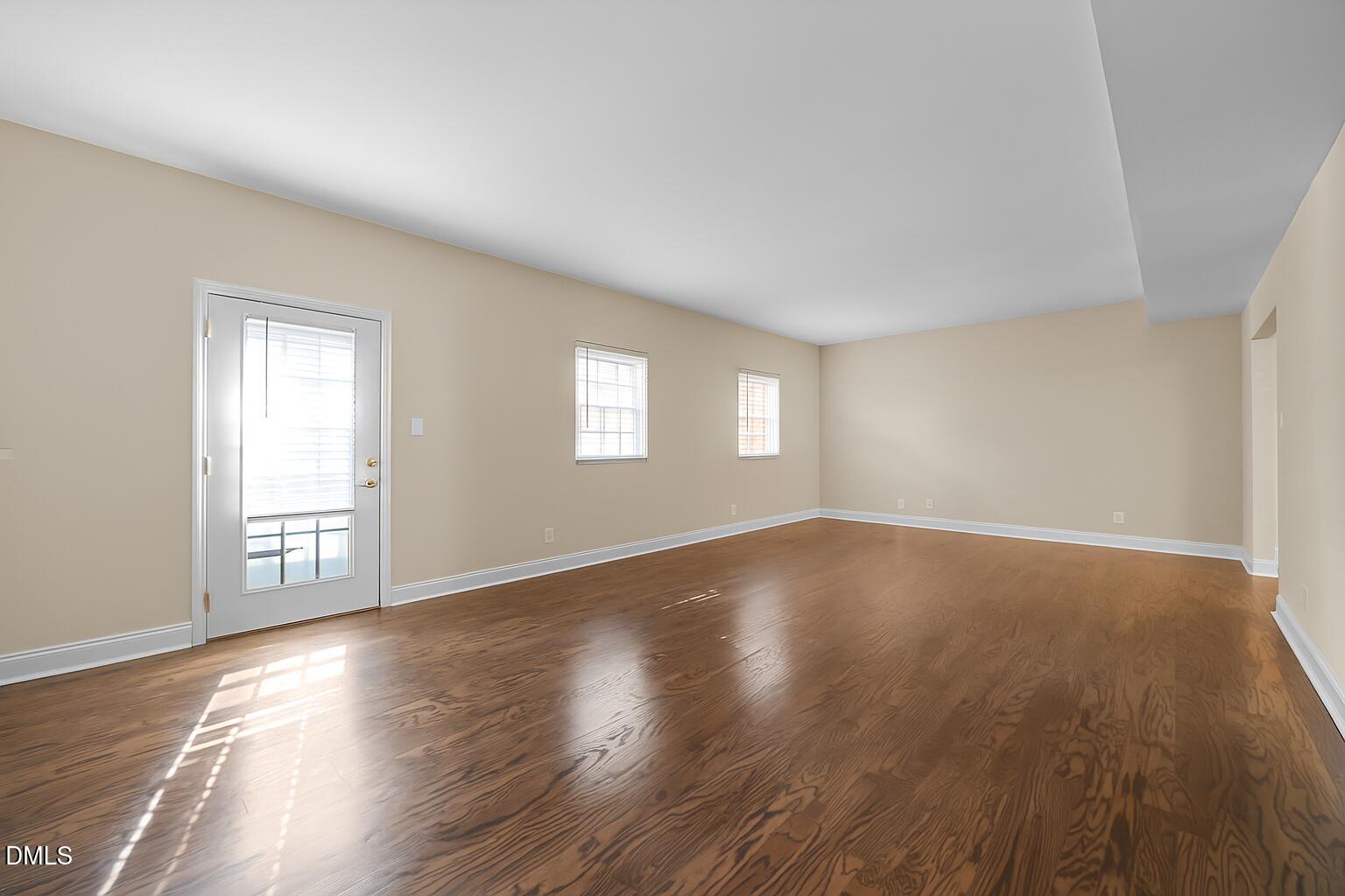 6423 New Market Way Raleigh, NC 27615 - Photo 7 of 33 a view of an empty room with wooden floor and window