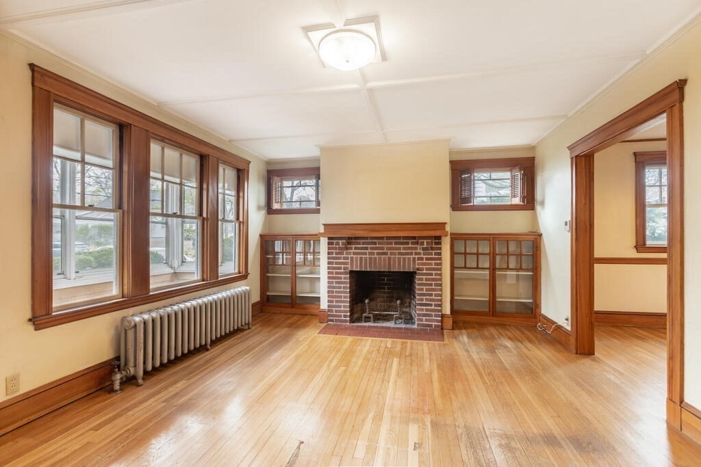 145 Robbins Road Arlington, MA 02476 - Photo 4 of 31 a view of an empty room with wooden floor fireplace and a window