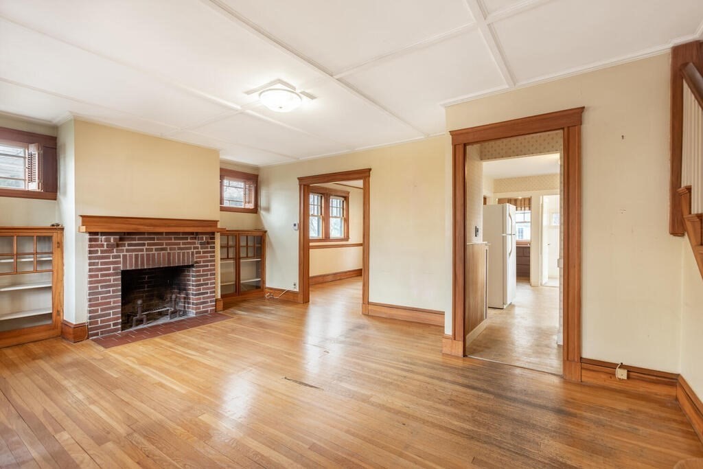 145 Robbins Road Arlington, MA 02476 - Photo 7 of 31 a view of an empty room with wooden floor fireplace and a window