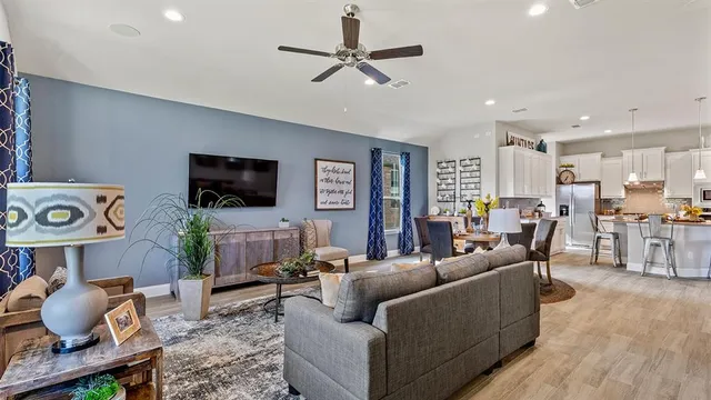 a living room with furniture a flat screen tv and a large window