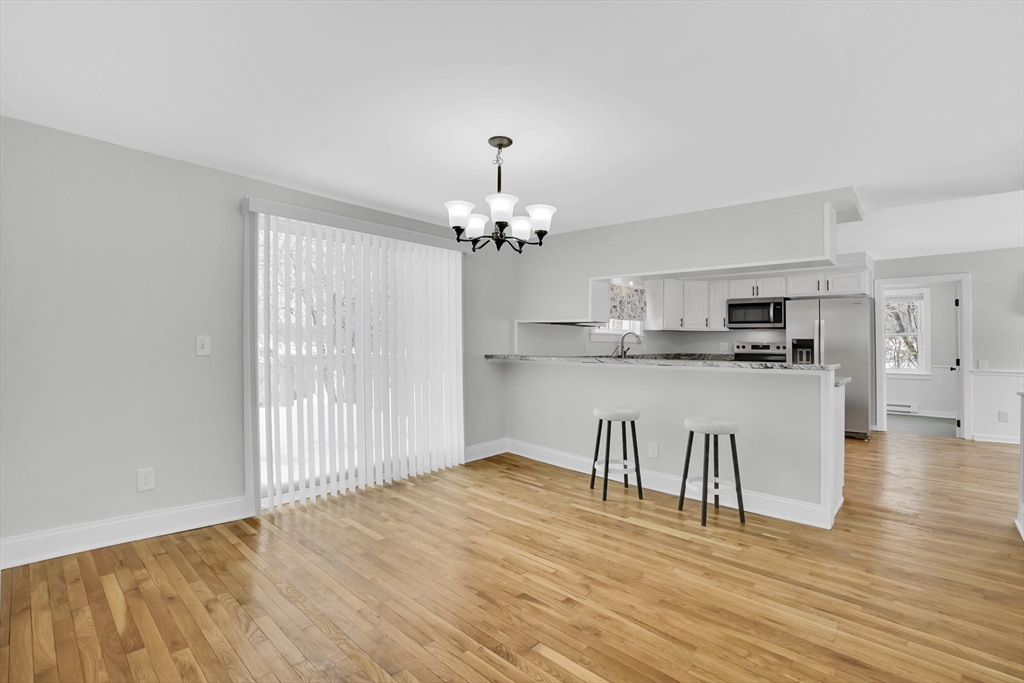 273 Dunhamtown Palmer Road Brimfield, MA 01010 - Photo 20 of 42 a kitchen with kitchen island stainless steel appliances a dining table chairs and chandelier