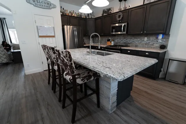 a bedroom with a bed wooden floor and a flat tv screen on dresser