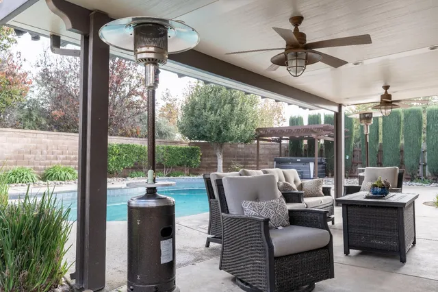 a view of a patio with a table and chairs and backyard