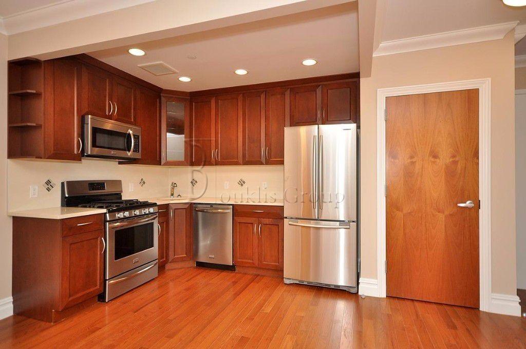a kitchen with wooden floors and stainless steel appliances