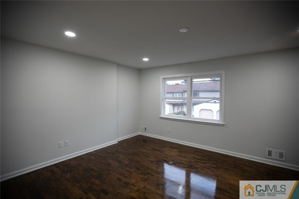 3402 Hana Road Edison, NJ 08817 - Photo 15 of 17 an empty room with wooden floor and windows