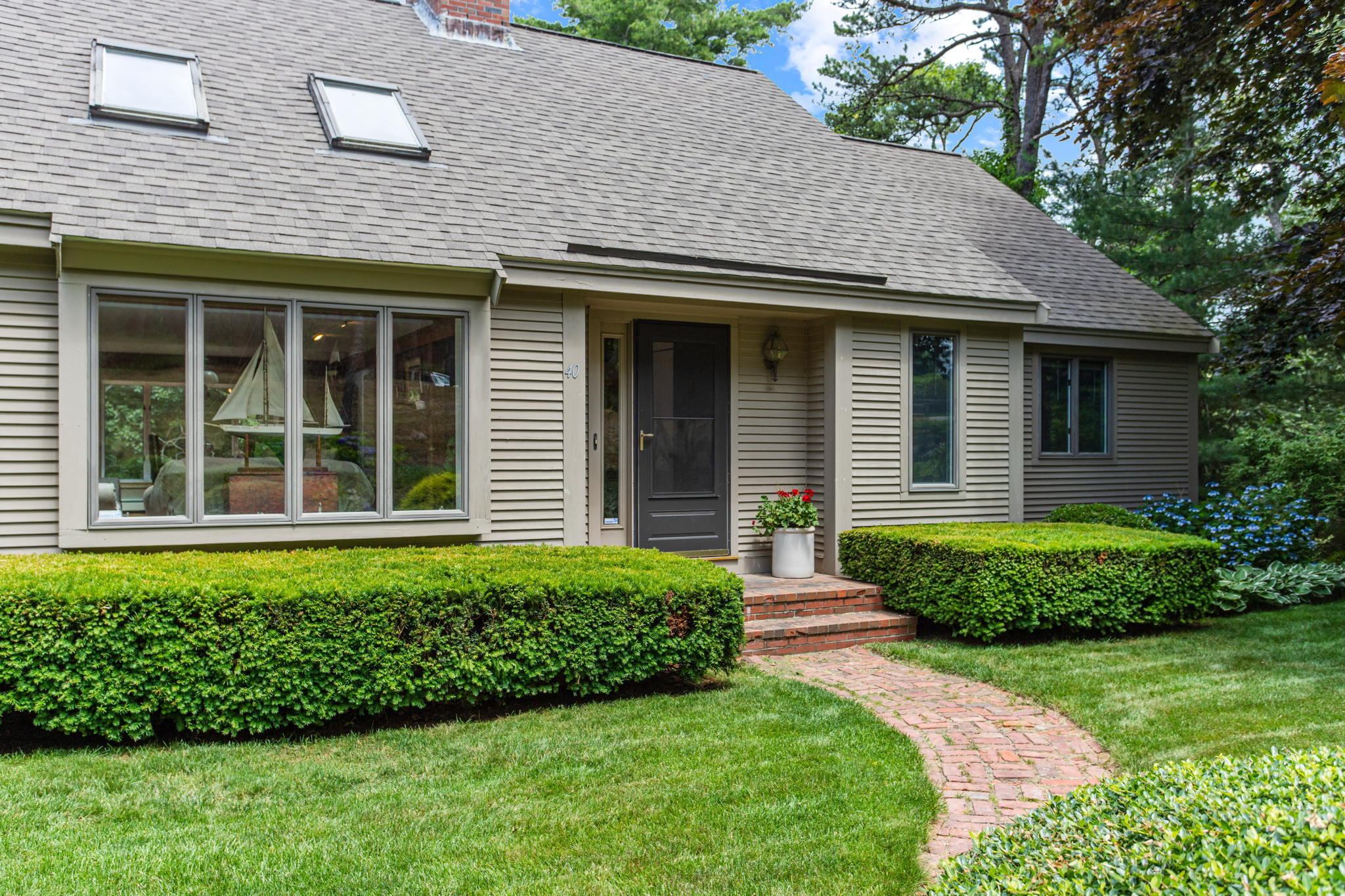 40 Point Isabella Road Cotuit, MA 02635 - Photo 4 of 28 a front view of a house with a yard