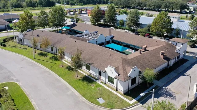 an aerial view of a house with a garden and lake view