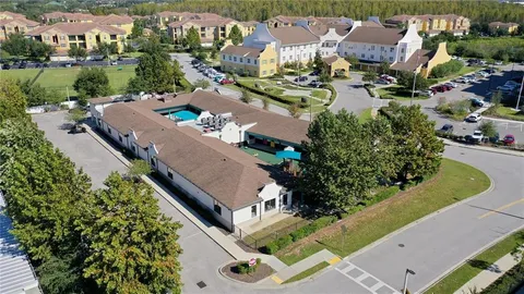 an aerial view of a house with a garden and lake view
