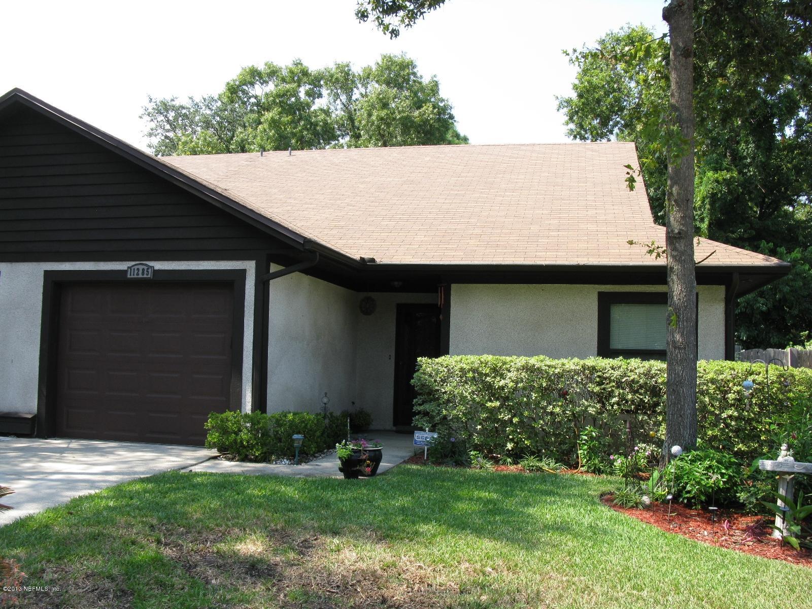 11285 Sawmill Road Jacksonville, FL 32225 - Photo 1 of 20 a backyard of a house with potted plants and a large tree