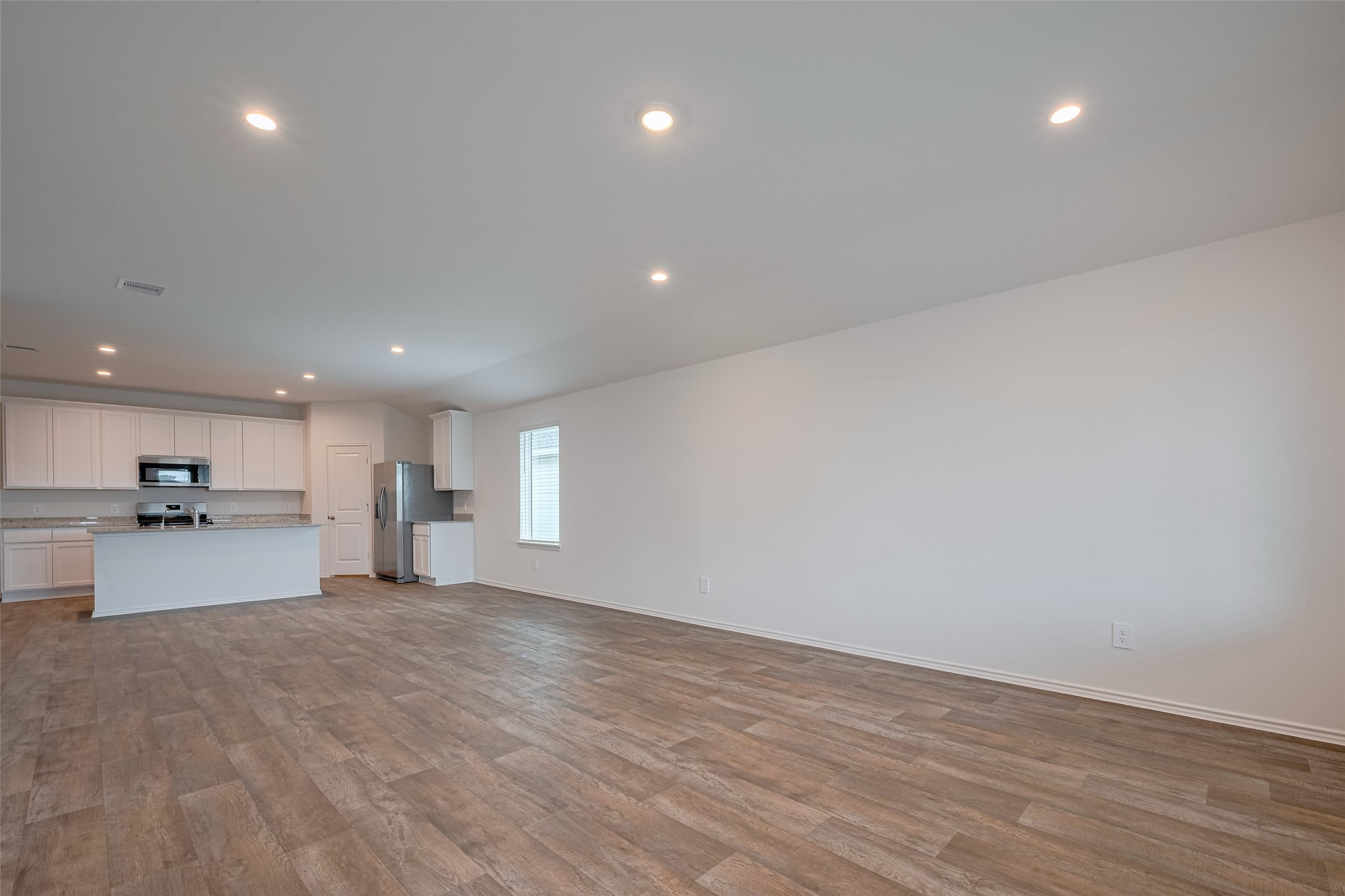 30910 Rockstock Road Fulshear, TX 77441 - Photo 5 of 33 The open layout stretches from the kitchen into the living area, offering an expanse that effortlessly accommodates both casual dining and relaxed gathering spaces.