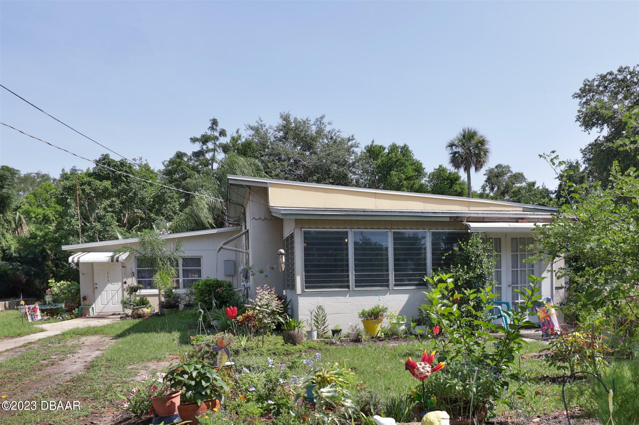 113 Evergreen Avenue Edgewater, FL 32132 - Photo 2 of 47 a house with flowers in front of it
