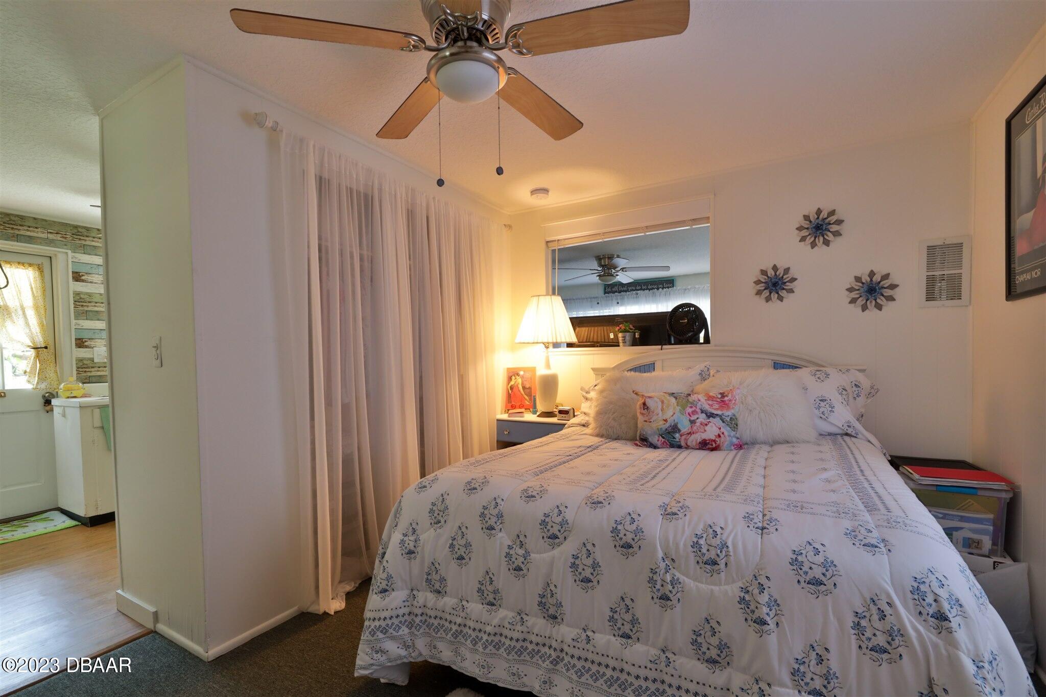 113 Evergreen Avenue Edgewater, FL 32132 - Photo 28 of 47 a bedroom with a bed and a chandelier