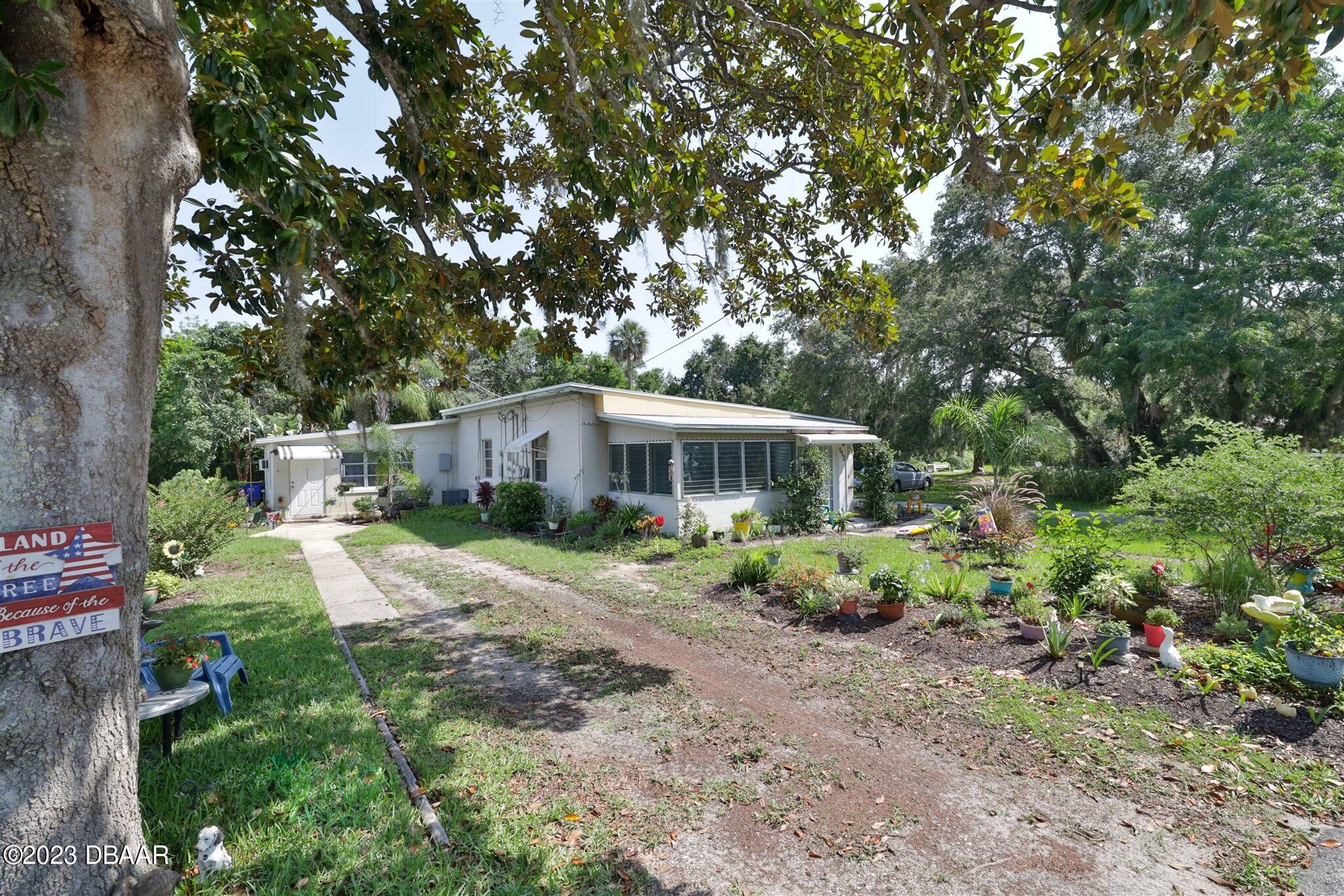 113 Evergreen Avenue Edgewater, FL 32132 - Photo 3 of 47 a front view of a house with a garden
