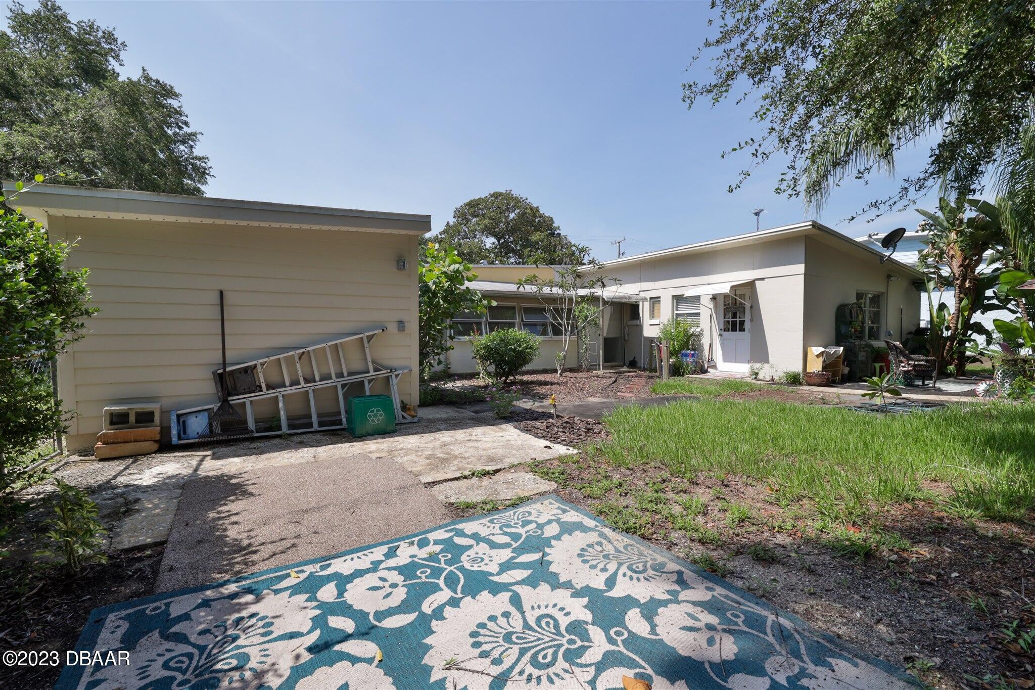 113 Evergreen Avenue Edgewater, FL 32132 - Photo 37 of 47 a view of a porch with a table and chairs under an umbrella