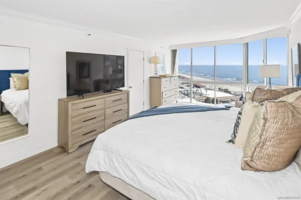 a spacious bedroom with a bed and a flat screen tv