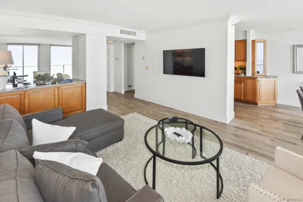 a living room with furniture a flat screen tv and wooden floor