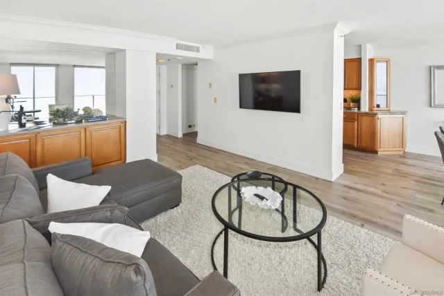 a living room with furniture a flat screen tv and wooden floor