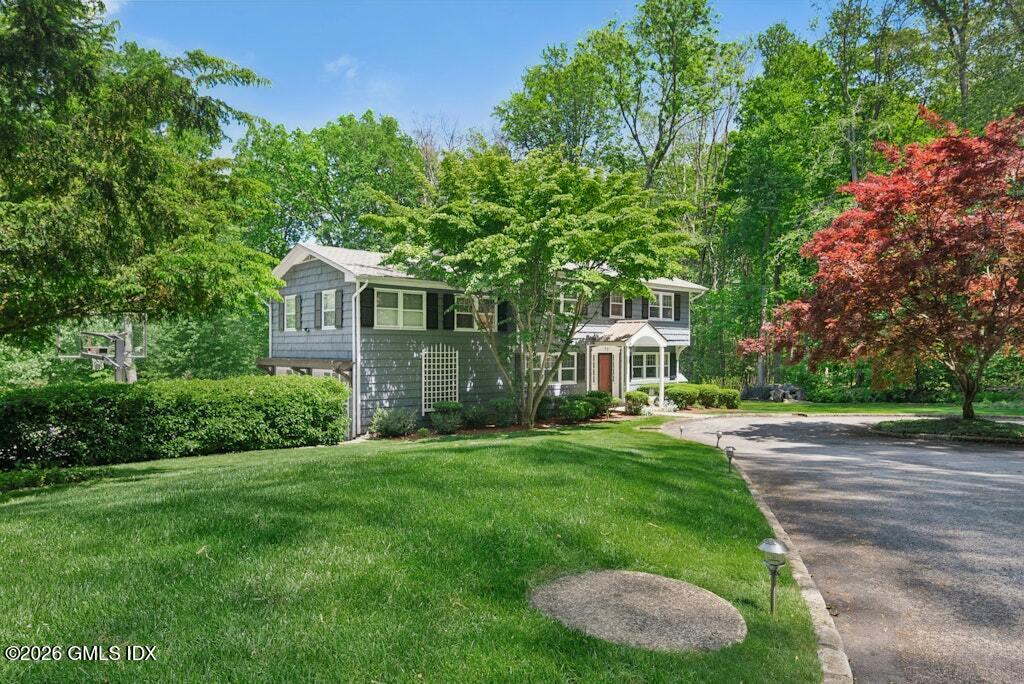 73 Thunder Mountain Road Greenwich, CT 06831 - Photo 3 of 19 a front view of a house with a yard and trees