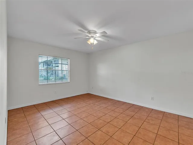a view of an empty room and chandelier fan