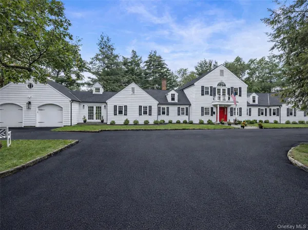 a front view of a house with a garden and trees