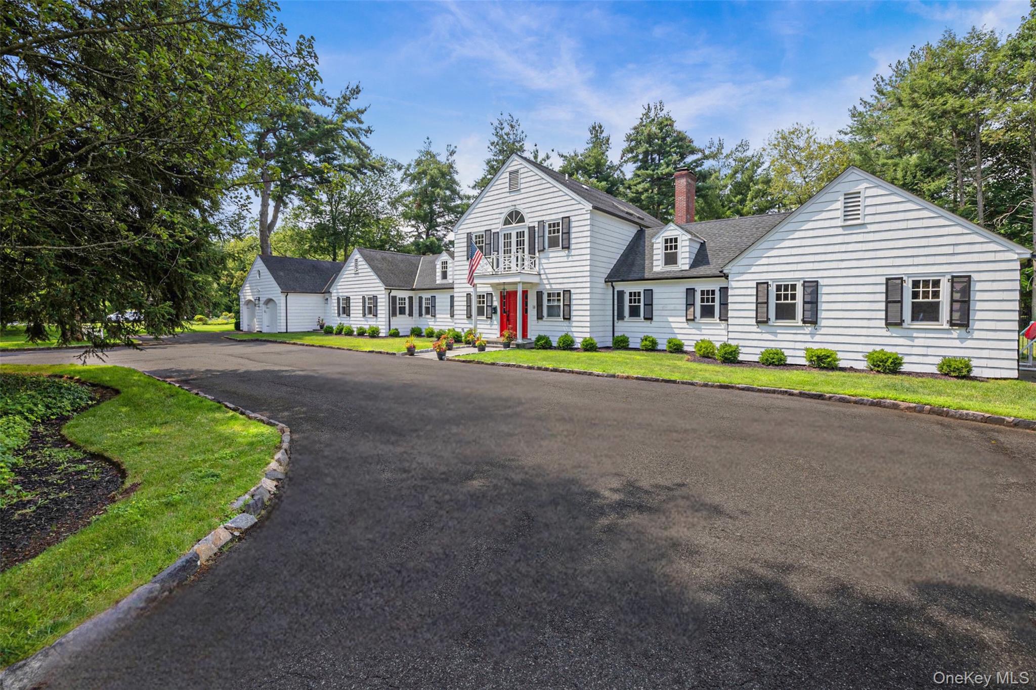 18 Lakeside Drive Rye, NY 10580 - Photo 2 of 43 a front view of a house with a garden and trees