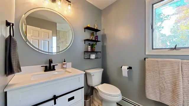 a bathroom with a toilet sink and mirror