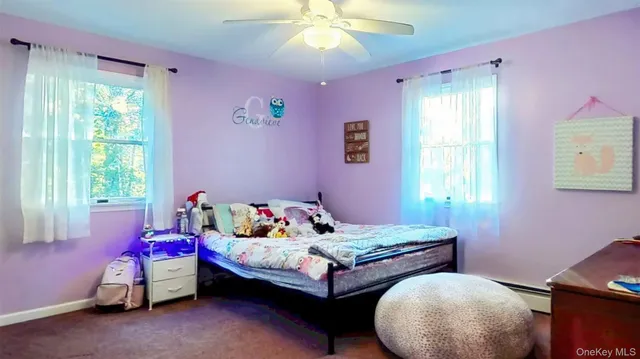 a bedroom with a bed and a flat tv screen on dresser