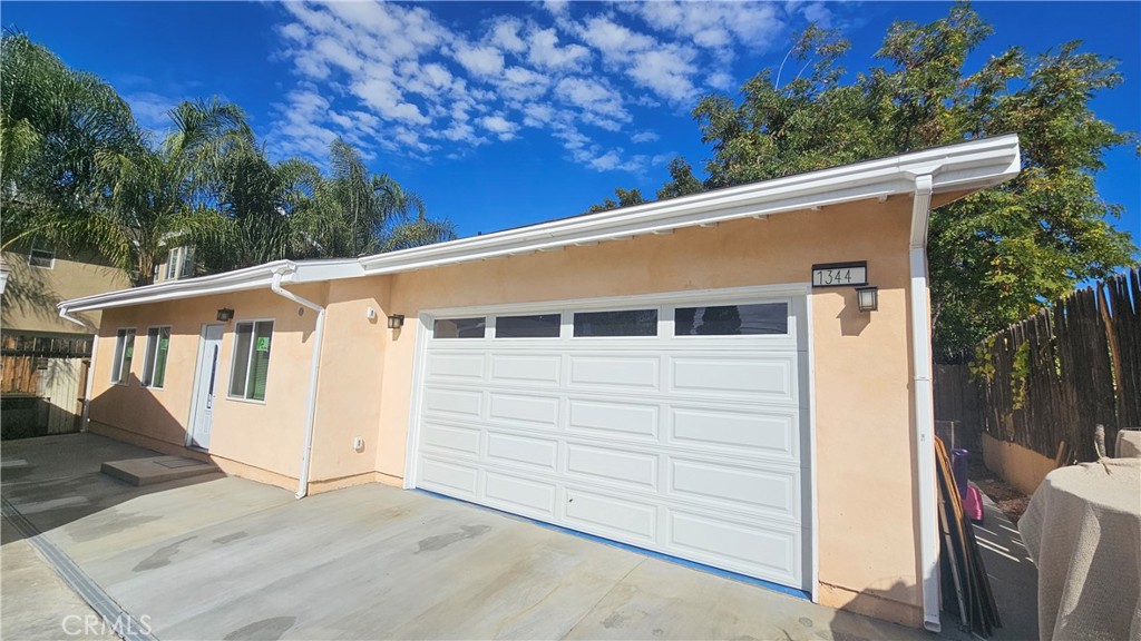 a view of a small house with wooden fence