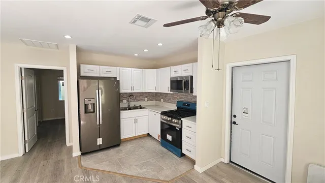 a kitchen with stainless steel appliances a refrigerator and a stove top oven