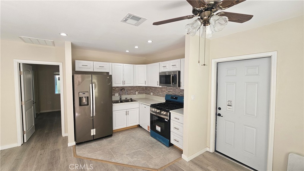 1344 Hardt Street San Bernardino, CA 92408 - Photo 4 of 12 a kitchen with stainless steel appliances a refrigerator and a stove top oven