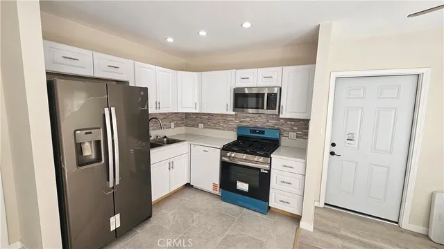 a kitchen with stainless steel appliances a refrigerator stove and microwave