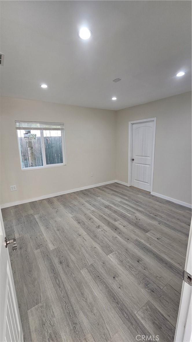 1344 Hardt Street San Bernardino, CA 92408 - Photo 8 of 12 an empty room with wooden floor and windows