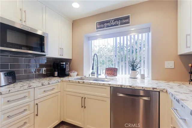 a kitchen with granite countertop cabinets stainless steel appliances and a sink