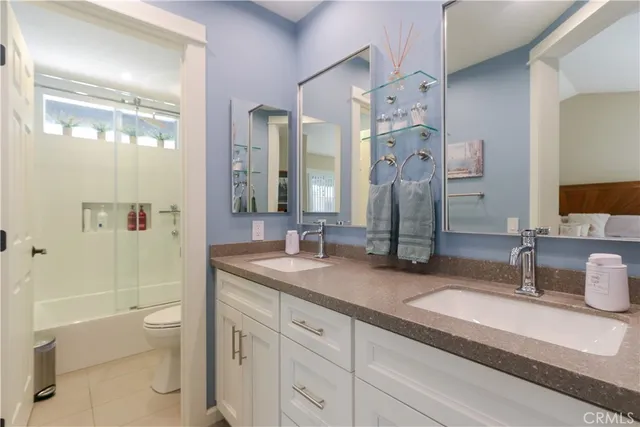 a bathroom with a double vanity sink toilet and shower