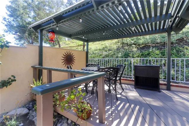 a view of a patio with table and chairs potted plants and floor to ceiling window